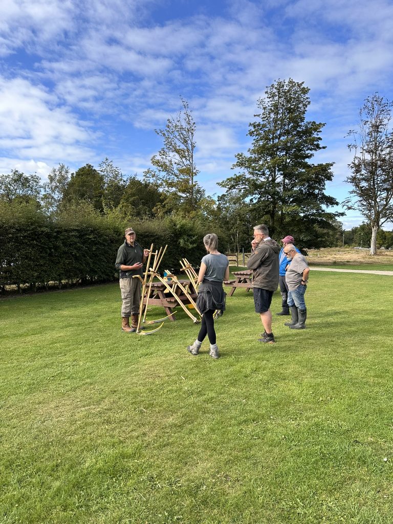 Doug Gooday, Scything trainer, delivering a scything workshop at Aden Country Park